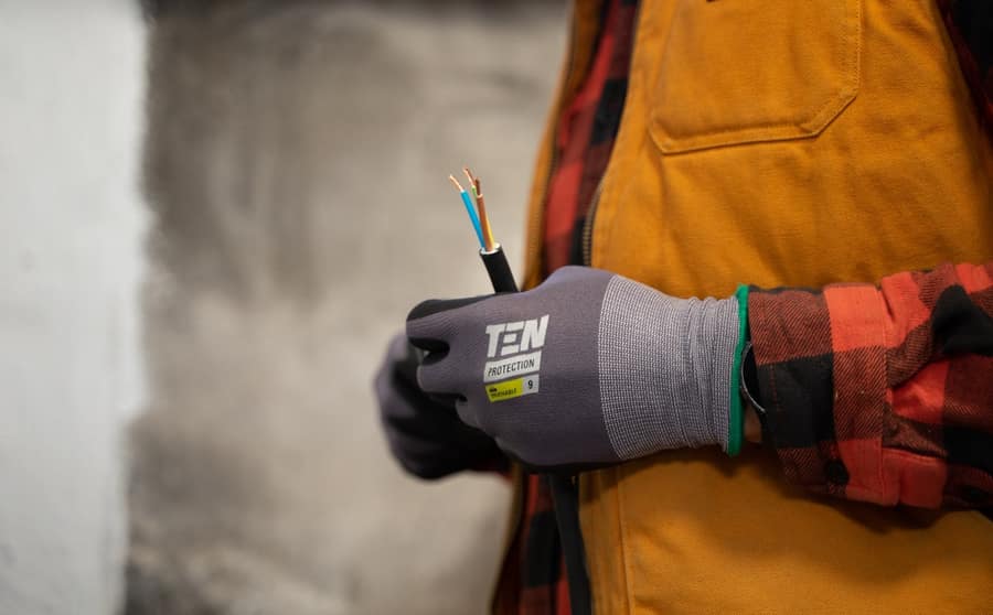 Gloved hands holding stripped electrical cable