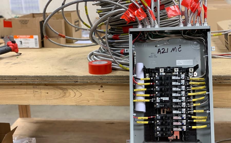 A residential breaker panel with the cover off, being wired